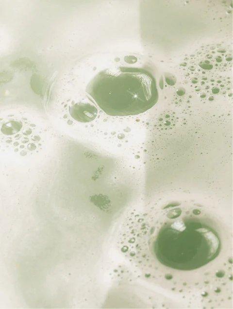 Eclat Soin Gloss Shampoo with Aloe Vera & Wheat Protein creating a rich, bubbly lather in a light green color